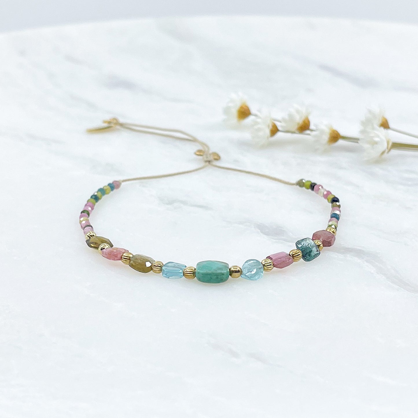 Bracelet ajustable en pierres fines naturelles. Au centre une Agathe d'Herbe carrée verte. Encadrée de six Tourmalines multicolores et deux Aigue-marine.