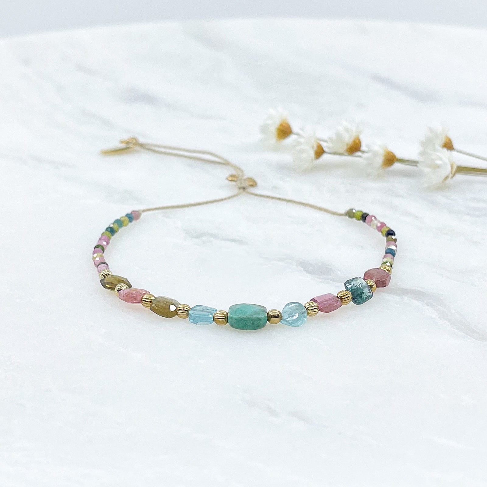 Bracelet ajustable en pierres fines naturelles. Au centre une Agathe d'Herbe carrée verte. Encadrée de six Tourmalines multicolores et deux Aigue-marine.