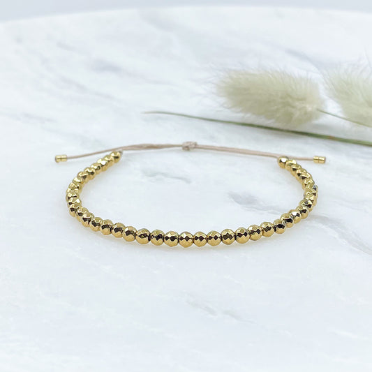 Bracelet ajustable en perles facettées d'hématite dorées