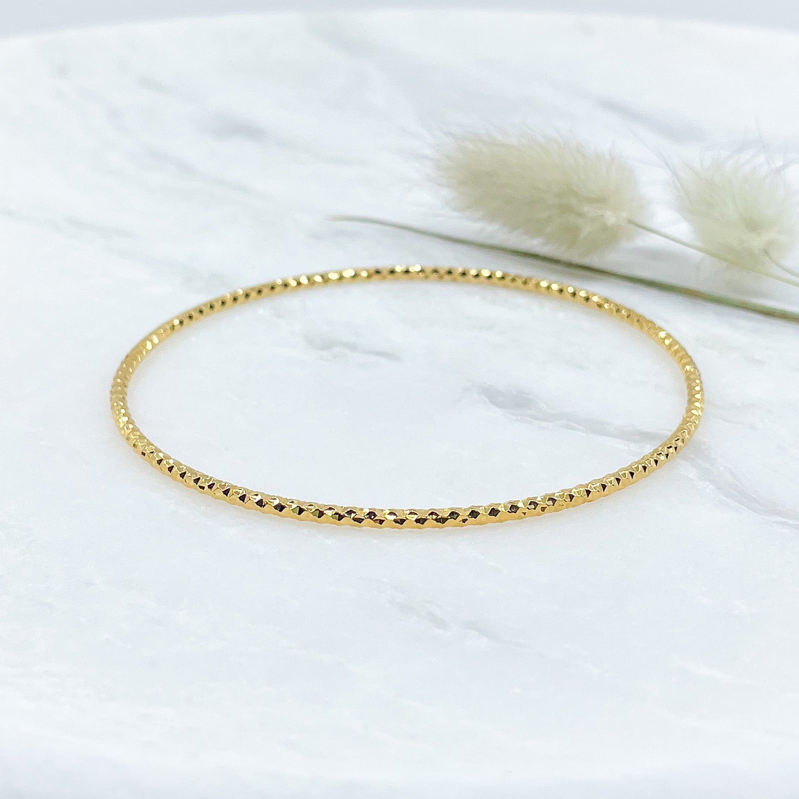 Jonc scintillant en plaqué or pour sublimer votre poignet avec sa structure facettée.