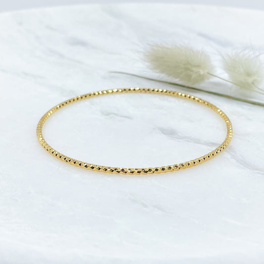 Jonc scintillant en plaqué or pour sublimer votre poignet avec sa structure facettée.