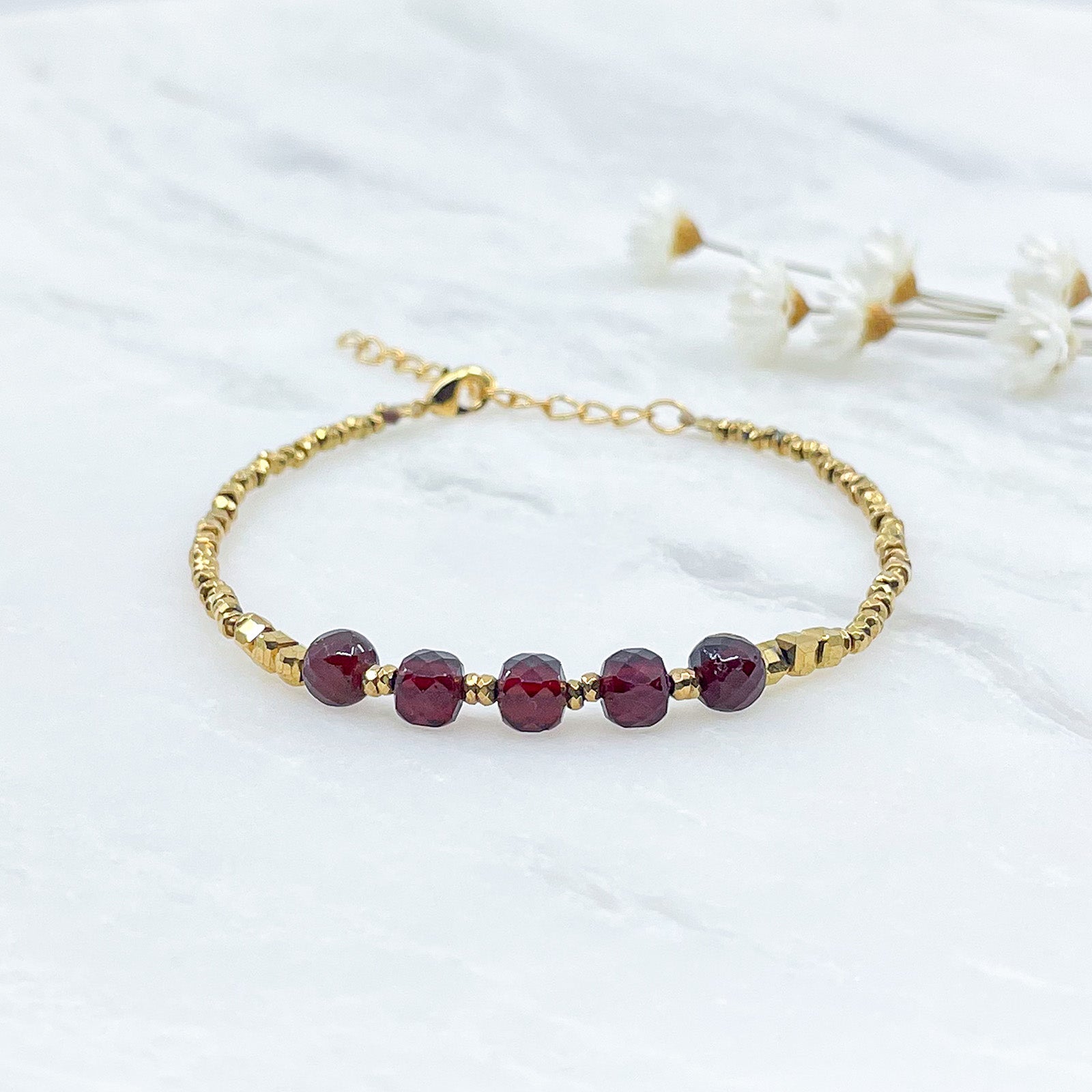 Bracelet pierres naturelles de Grenat en perles facettées et hématites dorées.