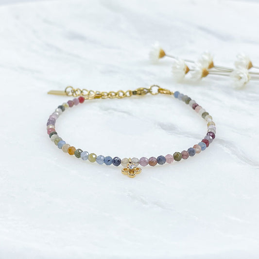 Bracelet pierres naturelles perles de tourmaline multicolores. En son centre un petit pendentif trèfle doré serti d'un cristal.