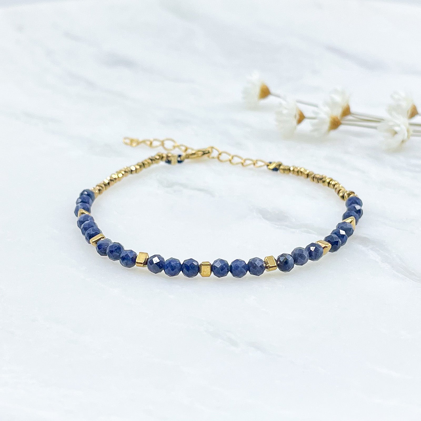 Bracelet perles de pierres fines naturelles variées au coloris assortis. S'enroule en deux tours autour du poignet. Montées sur cordon avec fermoir et chaîne de rallonge.