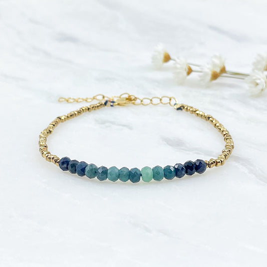 Bracelet en perles de pierres fines naturelles de Tourmaline bleu-vert intense. Elle sont encadrées de perles d'Hématites dorées.