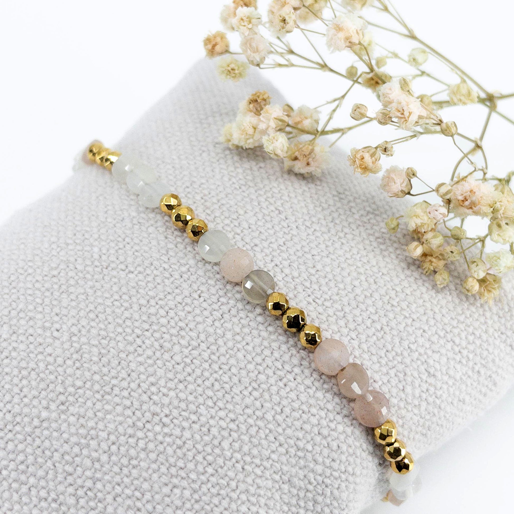 Bracelet ajustable en pierres fines naturelles Pierre de Soleil aux nuances blanches et rosées et perles d'hématites dorées.