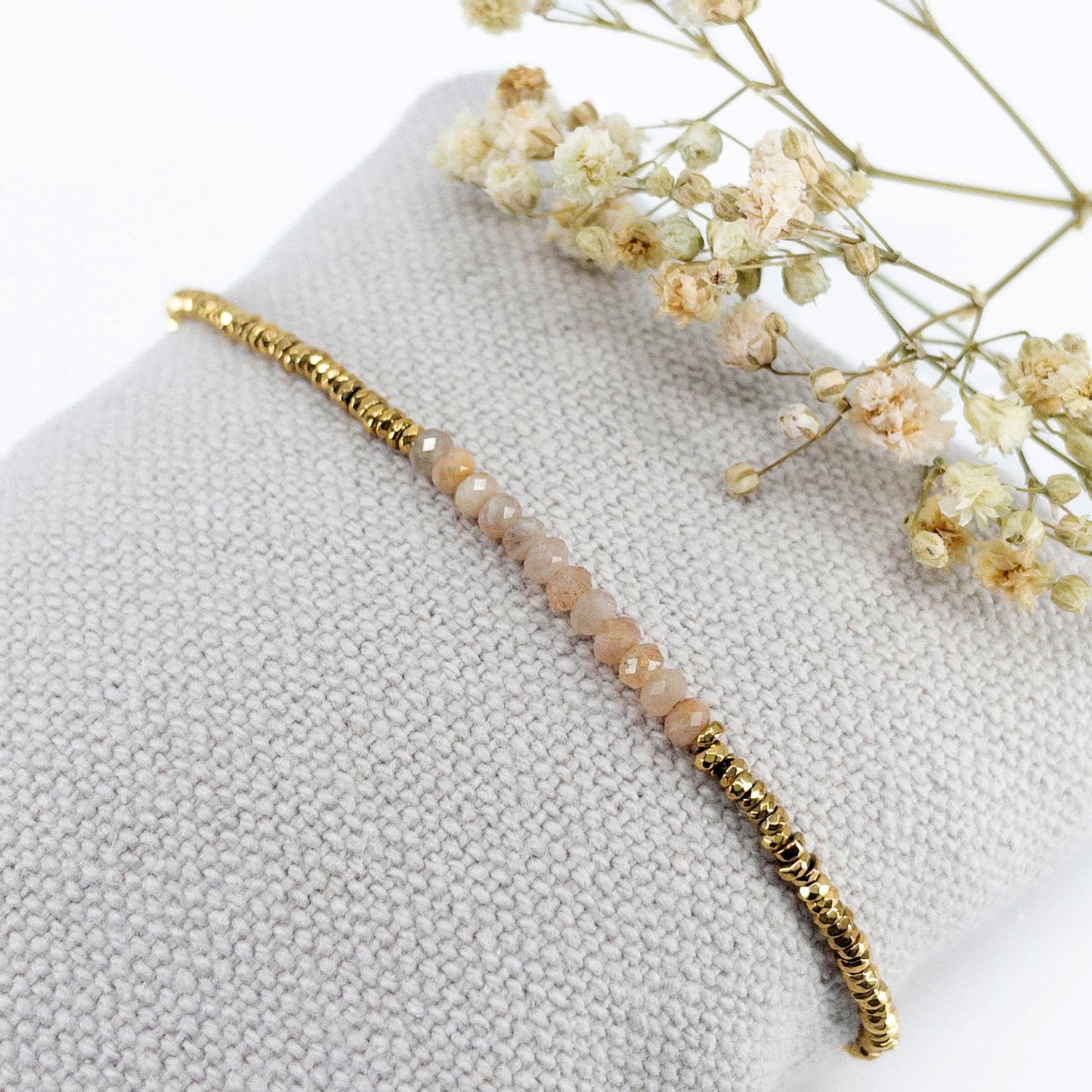 Bracelet ajustable en pierres fines naturelles Pierre de Soleil aux nuances rosées et perles d'hématites dorées.