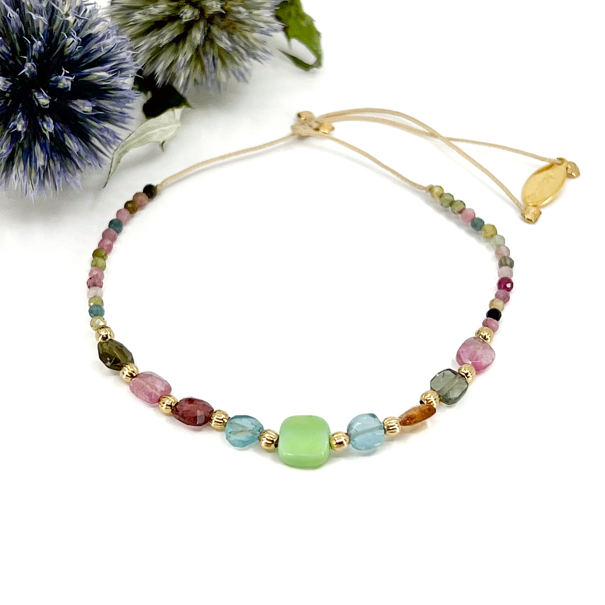 Bracelet ajustable en pierres fines naturelles. Au centre une Agathe d'Herbe carrée verte. Encadrée de six Tourmalines multicolores et deux Aigue-marine.