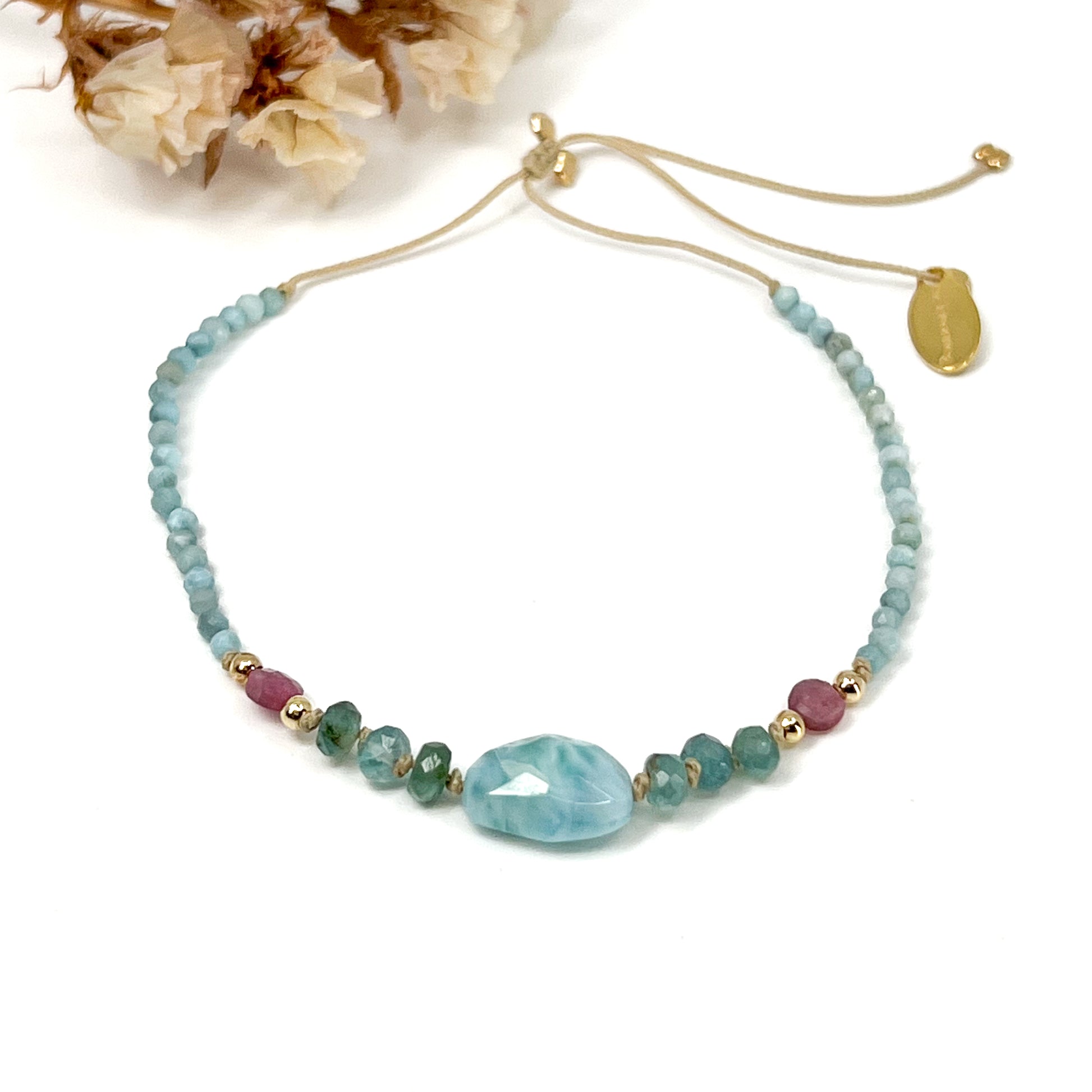 Bracelet aux teintes bleutées ajustable composé de pierres fines naturelles de larimar, d'une sélection de tourmaline et grandidierite encadrant un beau galet de Larimar bleu marin