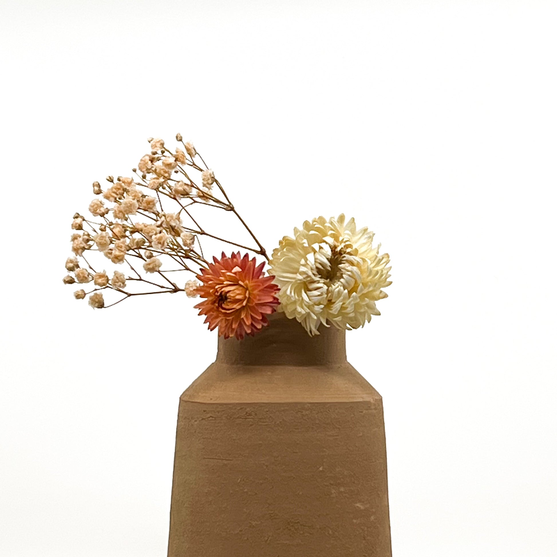 Vase au design épuré en terre cuite fait main. Hauteur 17 cm, largeur de la base 10 cm. Livré avec fleurs séchées offertes.