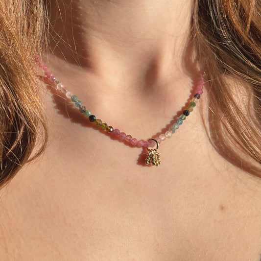 Collier rivière de perles de pierres fines naturelles de Tourmaline teinte arc-en-ciel. Pendentif composé de petites pierres d'hématite dorée. Chaîne de fermeture ajustable de 39 à 44 cm.