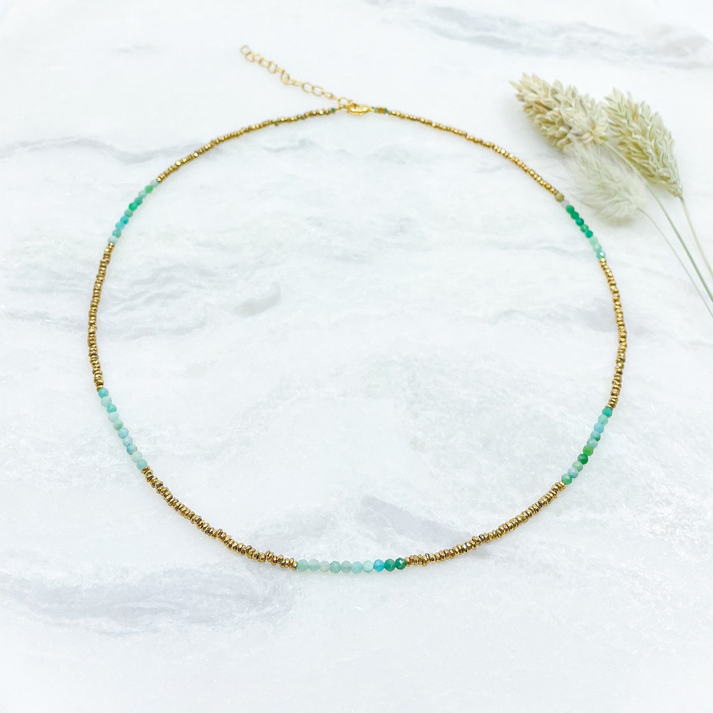 Collier en pierres fines naturelles d'amazonite aux différentes teintes de vert et hématite dorée. Longueur ajustable de 38-43 cm. Fermoir et chaîne d'extension en plaqué or.