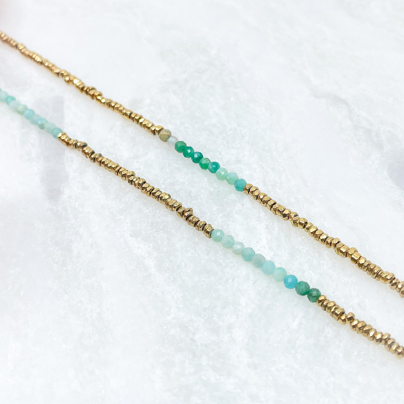 Collier en pierres fines naturelles d'amazonite aux différentes teintes de vert et hématite dorée. Longueur ajustable de 38-43 cm. Fermoir et chaîne d'extension en plaqué or.