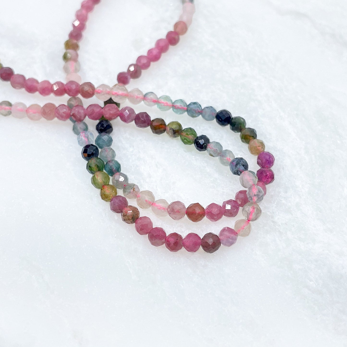 Collier rivière de perles de pierres fines naturelles de Tourmaline teinte arc-en-ciel. Pendentif composé de petites pierres d'hématite dorée. Chaîne de fermeture ajustable de 39 à 44 cm.