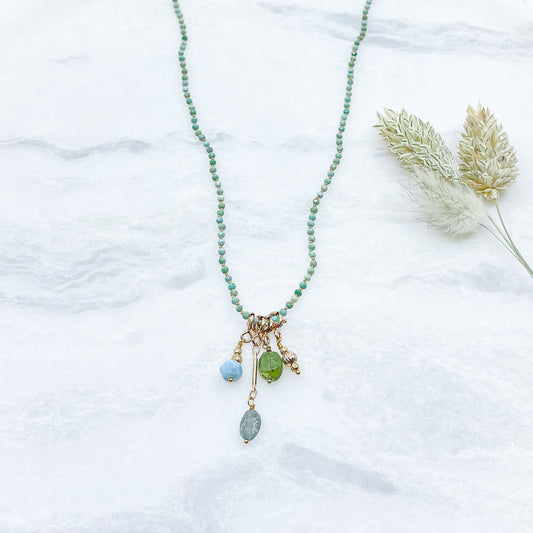Collier 36 cm en Turquoise aux tons verts et 4 charms composés de différentes pierres fines naturelles et d'un pendentif plaqué or