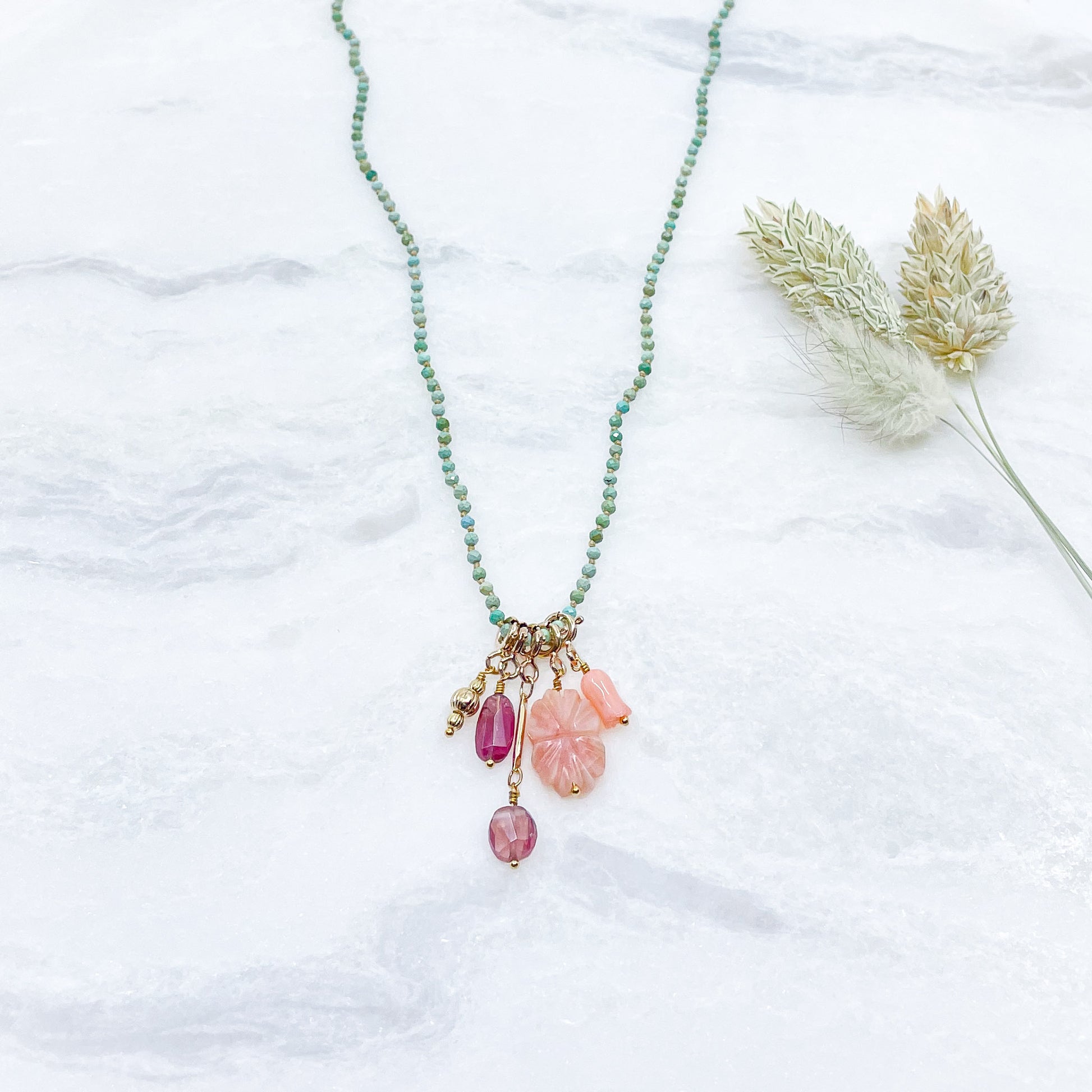 Collier 36 cm en Turquoise aux tons verts et 5 charms composés de différentes pierres fines naturelles et corail et d'un pendentif plaqué or