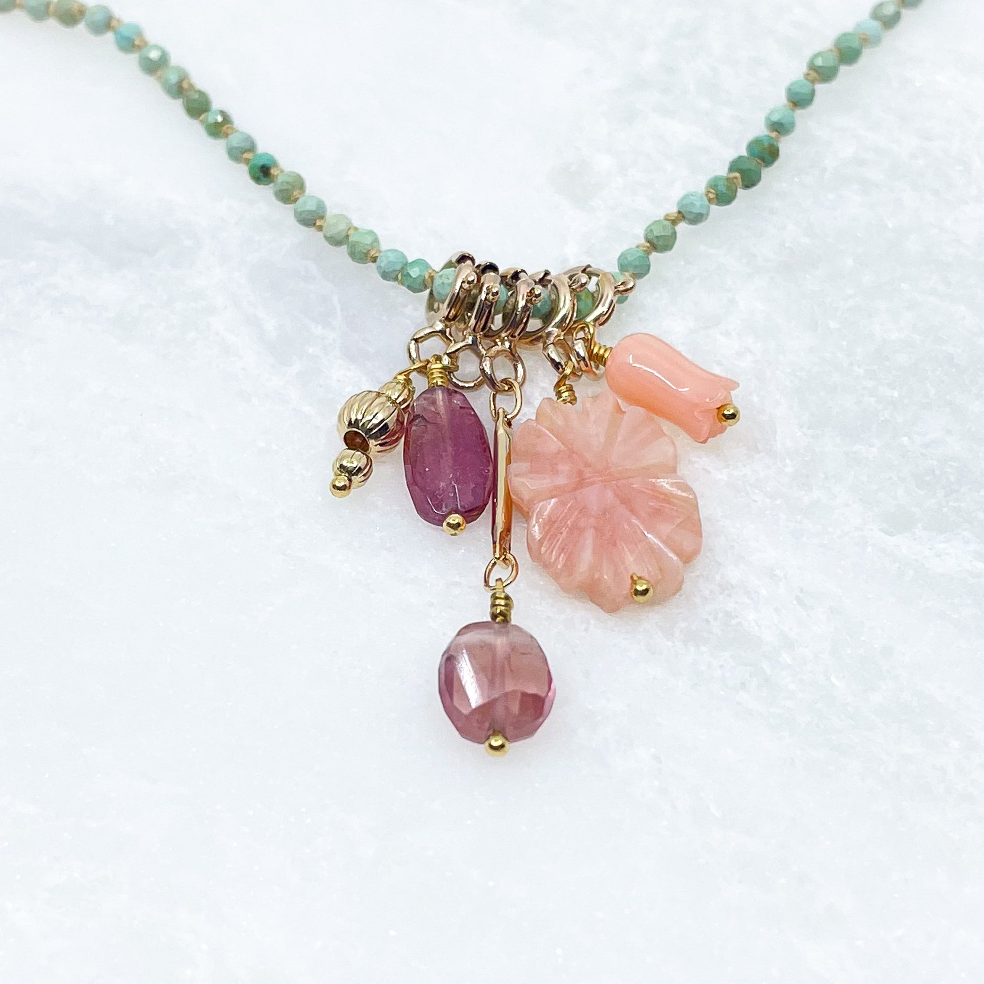 Collier 36 cm en Turquoise aux tons verts et 5 charms composés de différentes pierres fines naturelles et corail et d'un pendentif plaqué or