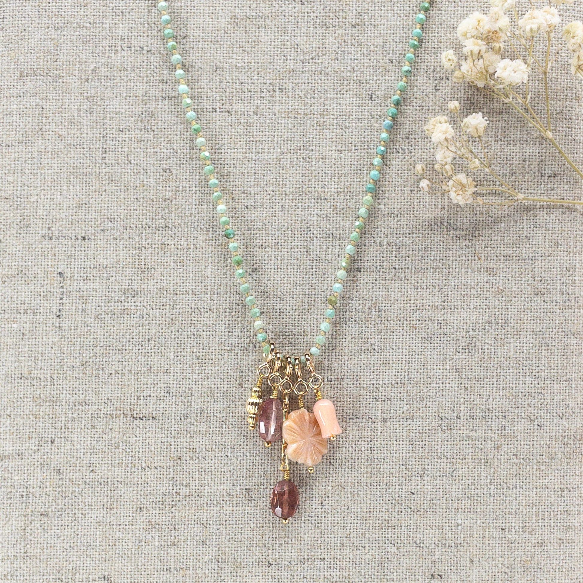 Collier 36 cm en Turquoise aux tons verts et 5 charms composés de différentes pierres fines naturelles et corail et d'un pendentif plaqué or
