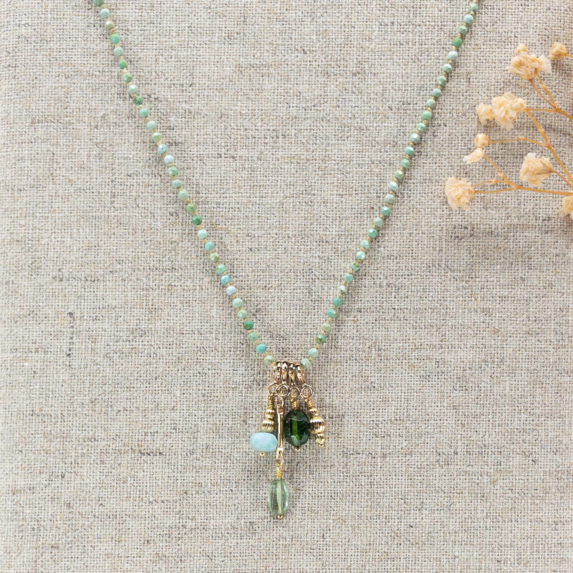 Collier 36 cm en Turquoise aux tons verts et 4 charms composés de différentes pierres fines naturelles et d'un pendentif plaqué or