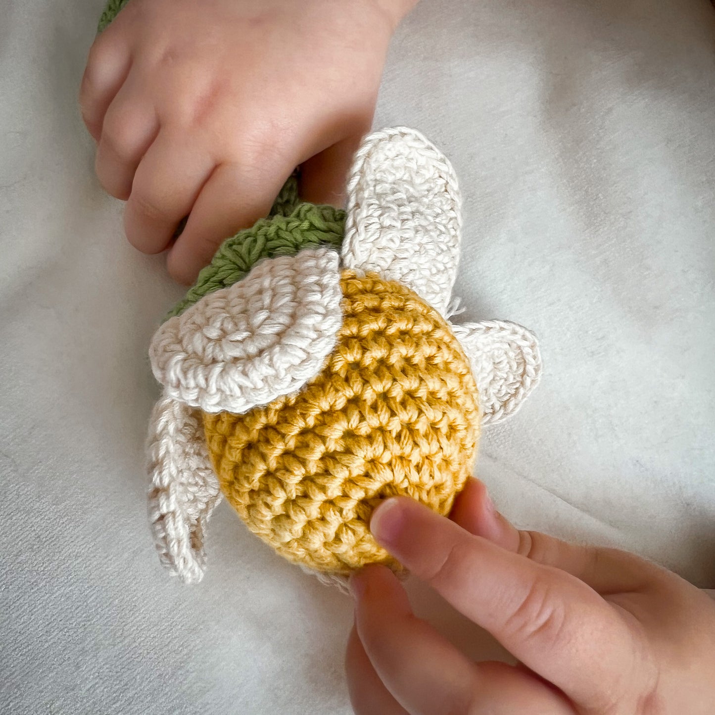 Hochet Fleur de Camomille pour bébé en crochet en coton bio fait main avec petit grelot. Hauteur 14cm, fleur blanche et cœur jaune.