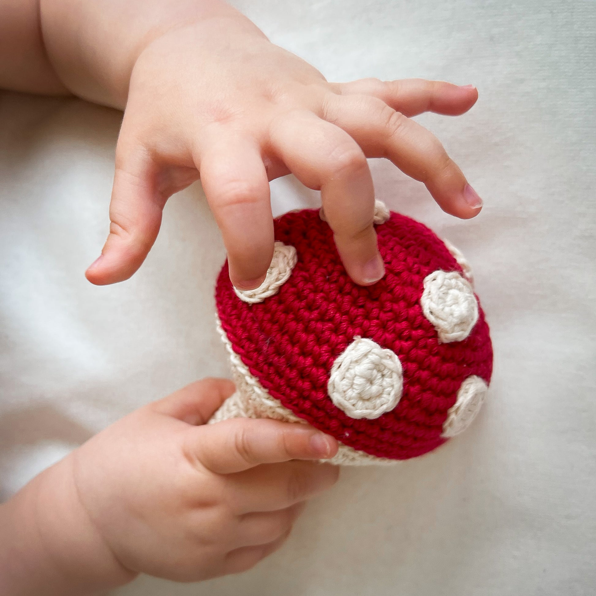 Hochet Champignon pour bébé en crochet en coton bio fait main avec petit grelot. Hauteur 14cm, couleur rouge et pois blancs