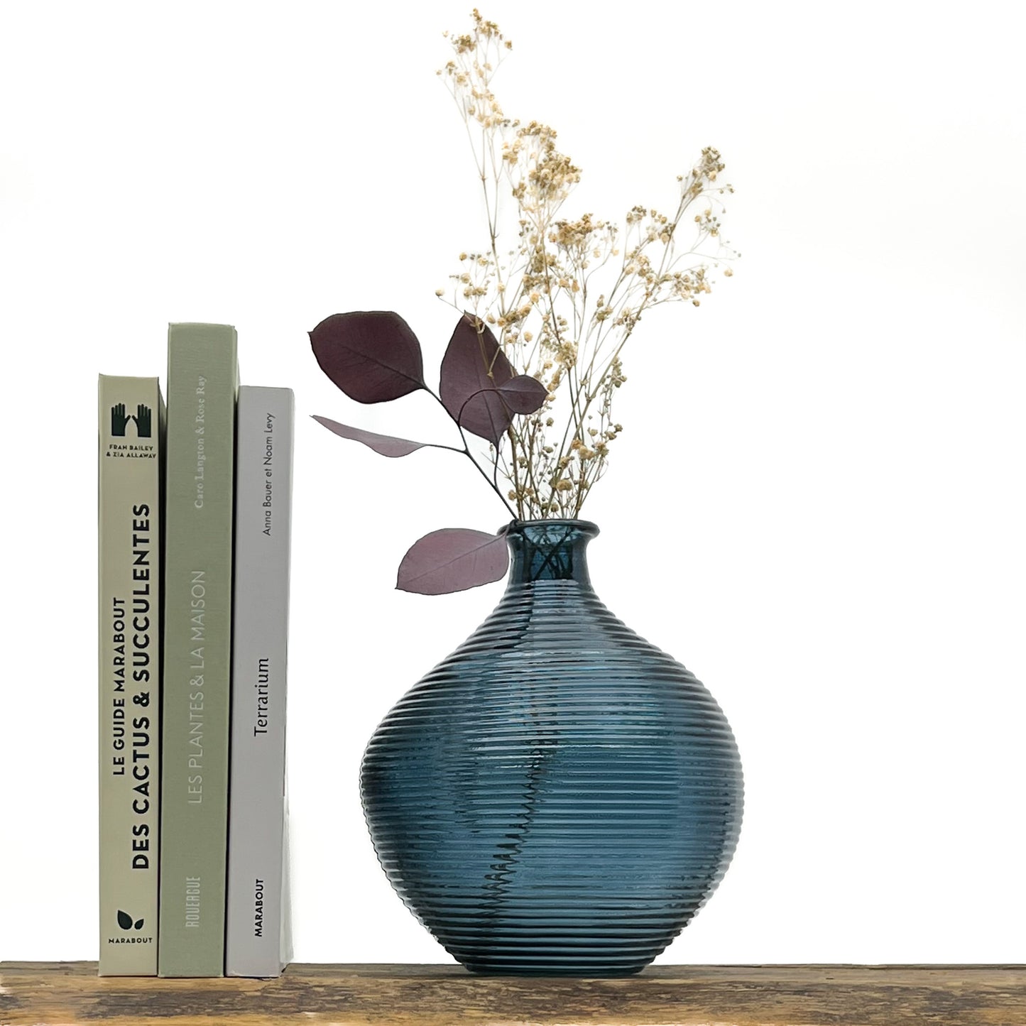 Vase en verre bleu cyclade. Hauteur 20 cm, diamètre 16.5 cm. Design épuré, stries le long du vase. Livré avec fleurs séchées offertes.